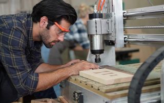 A carpenter staring at his work on a CNC machine